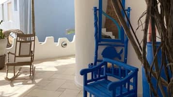 Relax in the outdoor patio area with a comfortable rocking chair and a play structure for kids.