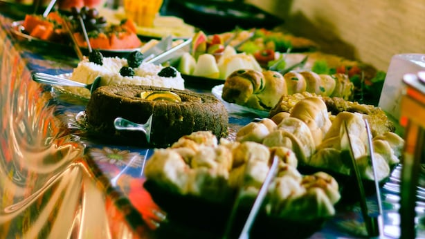 A buffet table with various food items.