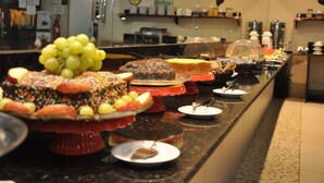 A buffet with various desserts and fruits. - Pousada Porto Familly (Ipojuca)