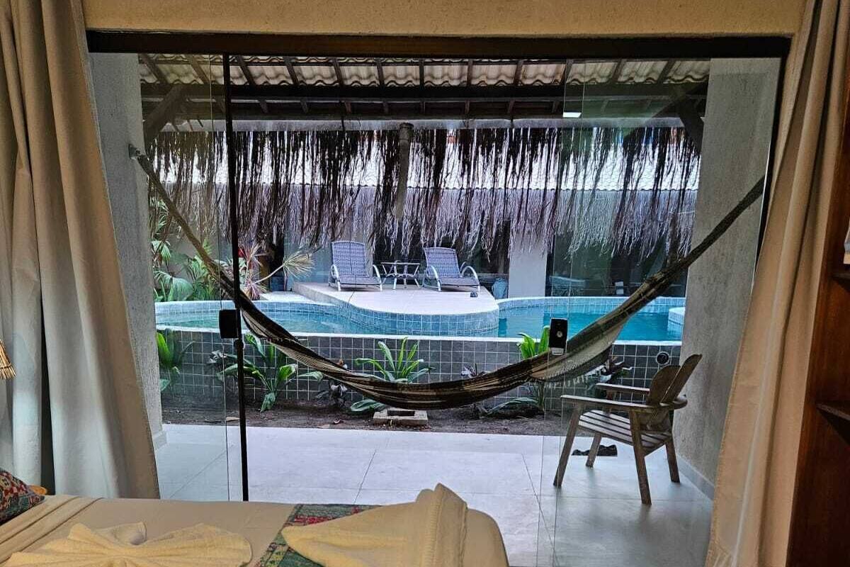 Un dormitorio con vista a una piscina y zona de estar al aire libre.