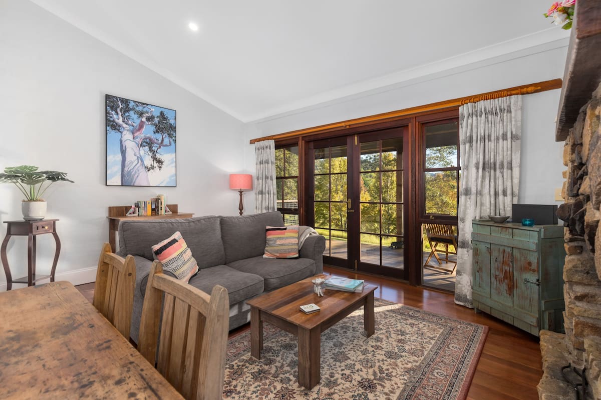 A living room with a sofa, coffee table, and a painting on the wall.