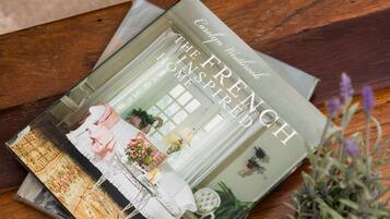 A book titled 'The French Home Inspired' on a wooden table with a small potted plant.