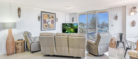 Apartamento familiar, 3 habitaciones, vistas parciales al mar, frente al mar | Sala de estar | Una televisión LED, un reproductor de DVD
