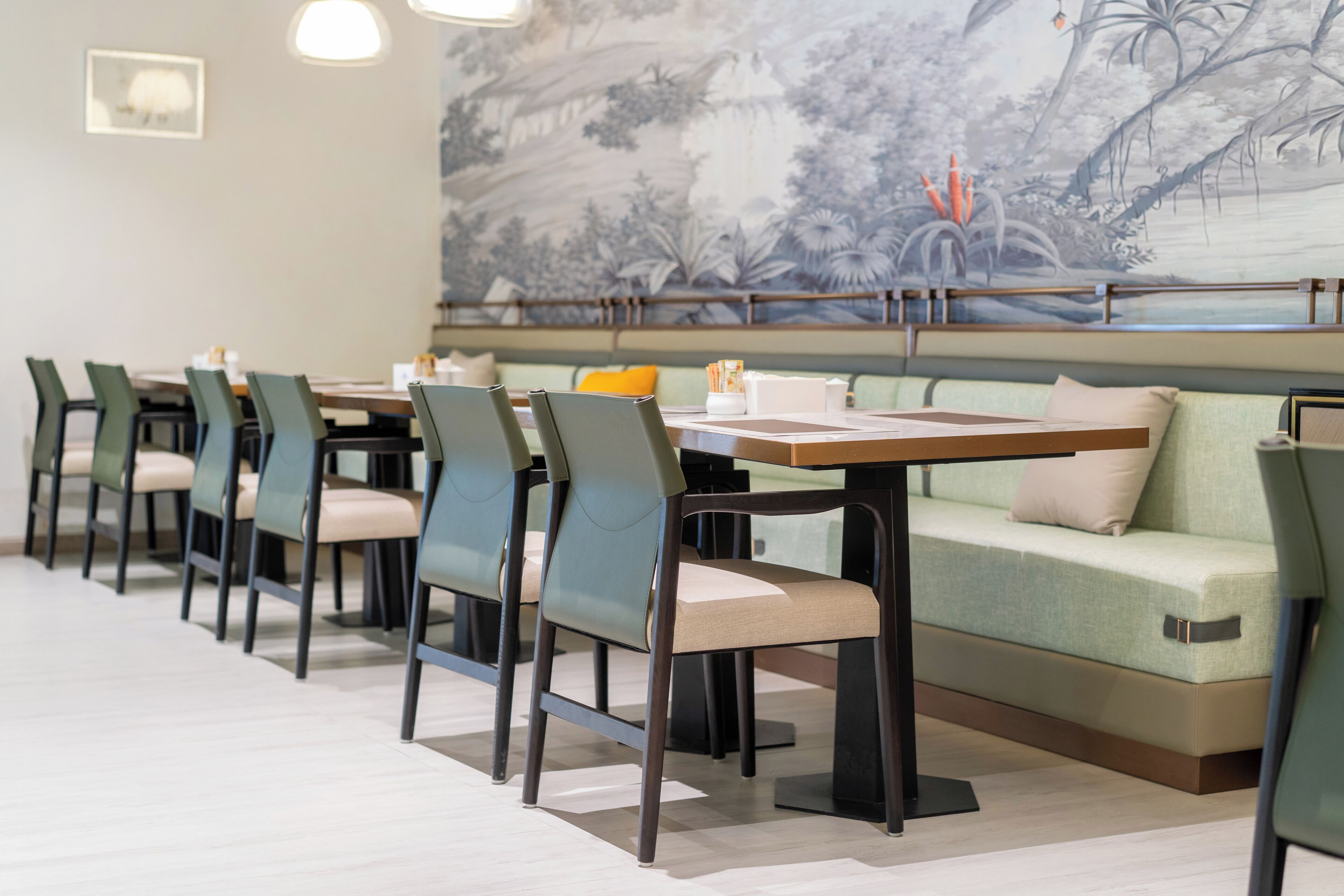 A restaurant with a long table, chairs, and a sofa.