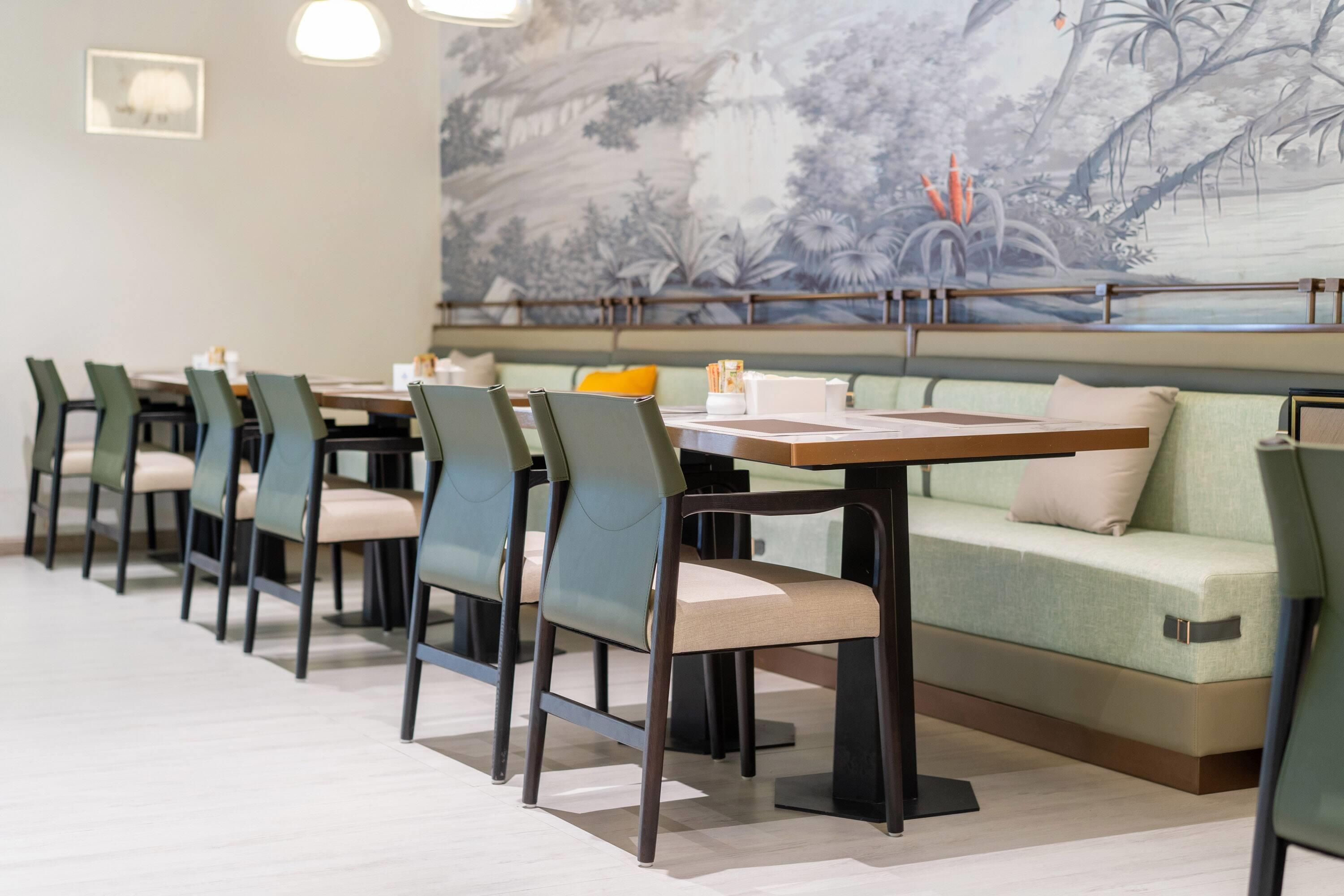 A restaurant with a long table, chairs, and a sofa.