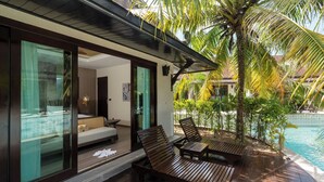 Uma villa moderna com piscina, deck de madeira e área de estar envidraçada.