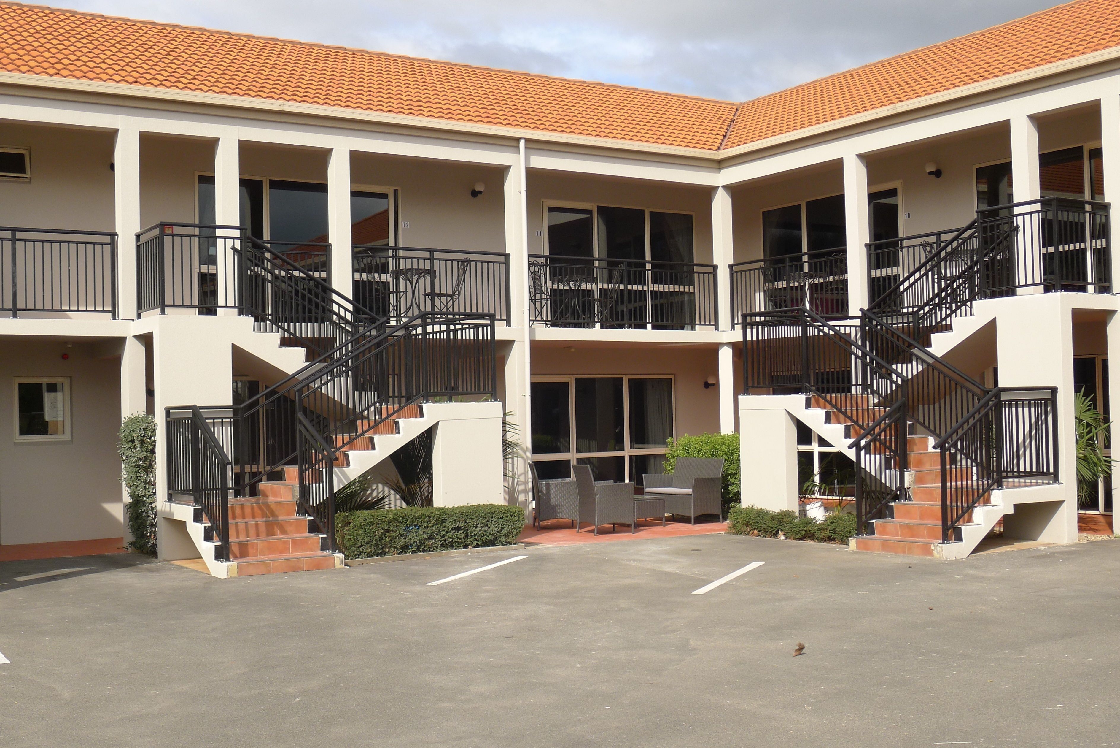A multi-story building with balconies, staircases, and outdoor seating areas.
