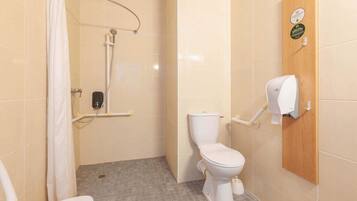 A bathroom with a shower, toilet, and hand dryer.