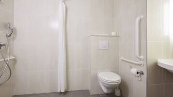 A bathroom with a shower, toilet, and grab bars.