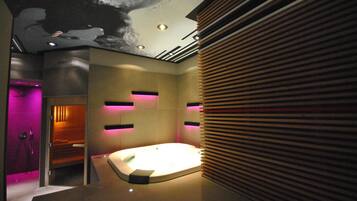 A modern bathroom with a freestanding bathtub, recessed lighting, and a wooden slatted wall design.