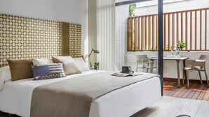 Habitación de hotel moderna con una cama grande, un escritorio y vistas al exterior.