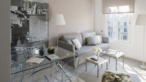 Una sala de estar moderna con un sofá, una mesa de centro y una mesa de comedor de vidrio.