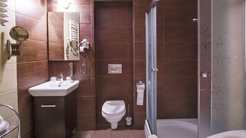 A modern bathroom with a shower, toilet, and sink.