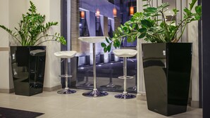 A modern interior with a reception area featuring a glass partition, a reception desk, and three bar stools. - Boutique Hotel’s II Rewolucji (Lodz)