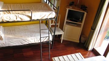 Cozy hotel room with a bunk bed setup, featuring a TV and a comfortable chair.
