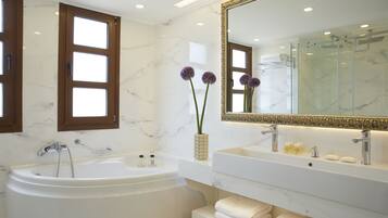 A modern bathroom with a freestanding bathtub, a large mirror, and a vanity with a sink and towel rack.