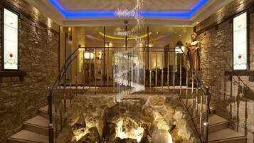 Un intérieur luxueux agrémenté d’un mur en pierre, d’une statue et d’un élément décoratif aquatique.