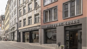 A hotel with a classic facade, multiple windows, and a sign reading "HOTEL ST GEORG". - Boutique Hotel St. Georg (Einsiedeln)