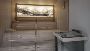 A sauna with a wooden bench and a large window displaying a mountainous landscape. - Boutique Hotel St. Georg (Einsiedeln)