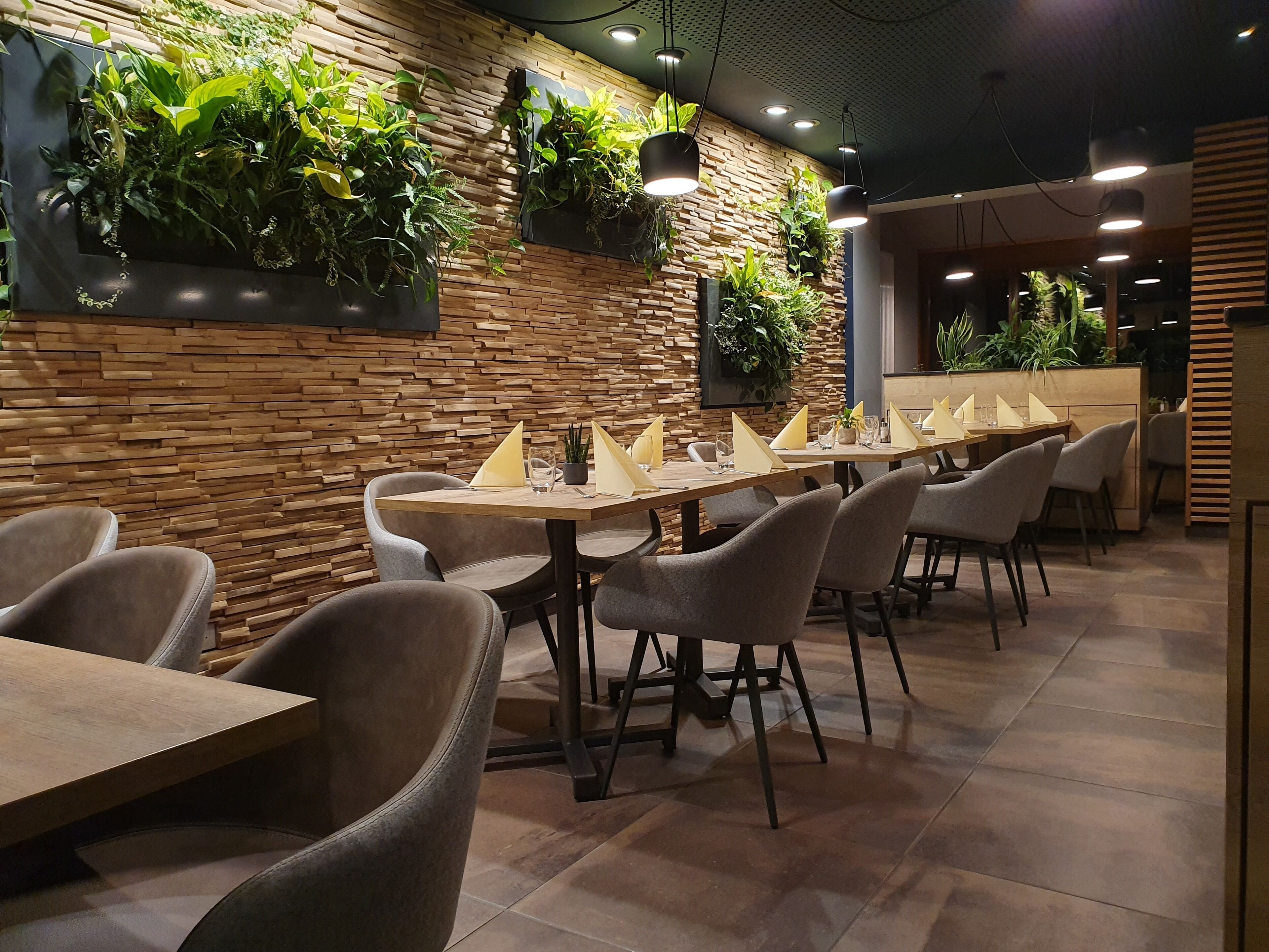 Un restaurante con paredes de madera, varias mesas y sillas.
