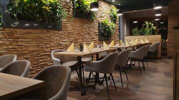 Un restaurante con paredes de madera, varias mesas y sillas.