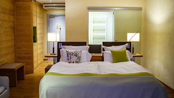 Una habitación de hotel con una cama grande, dos mesitas de noche, un escritorio y una silla.
