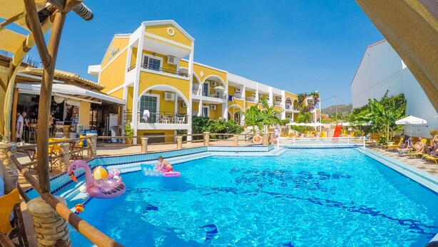 A hotel with a pool area, including lounge chairs and umbrellas. - Vanessa Hotel (Zakynthos)