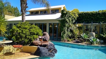 Una piscina al aire libre, tumbonas