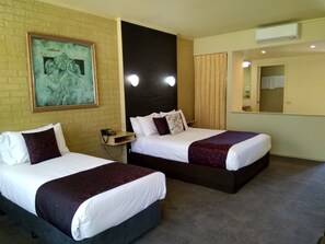 A hotel room with two beds, a painting on the wall, a bedside table with a phone, and an air conditioning unit. - Madison Spa Motel - Adults Only (Moama)