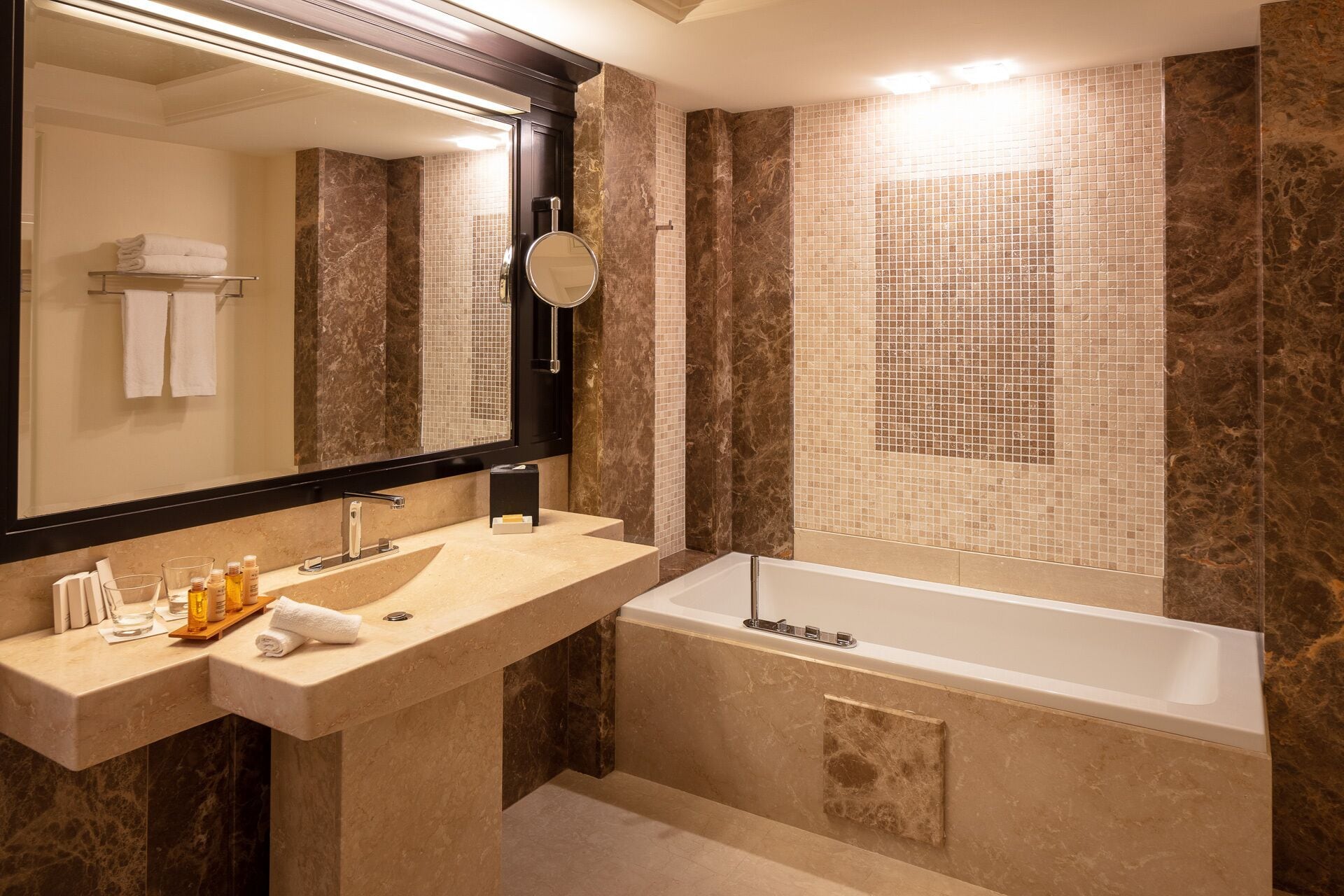Un baño moderno con tocador doble lavamanos, un espejo grande y una bañera independiente.