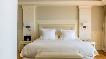 Una habitación de hotel ordenada con una cama grande, mesitas de noche y lámparas fijadas a la pared.