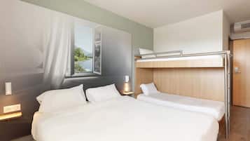 Habitación de hotel con dos camas, una ventana con vistas, una mesita de noche con lámpara y un equipo de aire acondicionado.