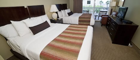 A hotel room with two beds, a TV, a dresser, and a balcony with a view.