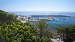 A coastal marina with boats, a pier, and a backdrop of clear blue sky. - Hotel Miramare (Dorgali)