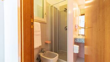 Een badkamer met een douche, een toilet met douchefunctie en een wastafel.