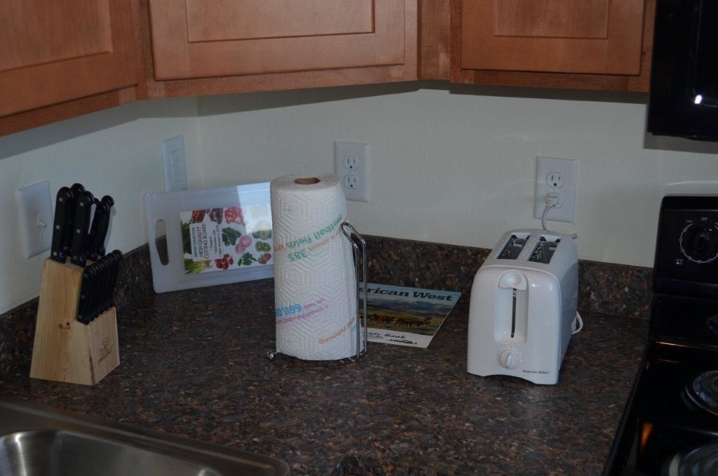 A kitchen counter with a roll of paper towels, a toaster, and a knife block.
