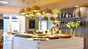 A buffet area with various food items and a bar with liquor bottles. - My Story Hotel Ouro (Lisbon)