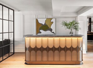 A modern reception desk with a wooden finish and a glass partition.