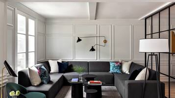 A modern living room with a sectional sofa, two round coffee tables, and a floor lamp.