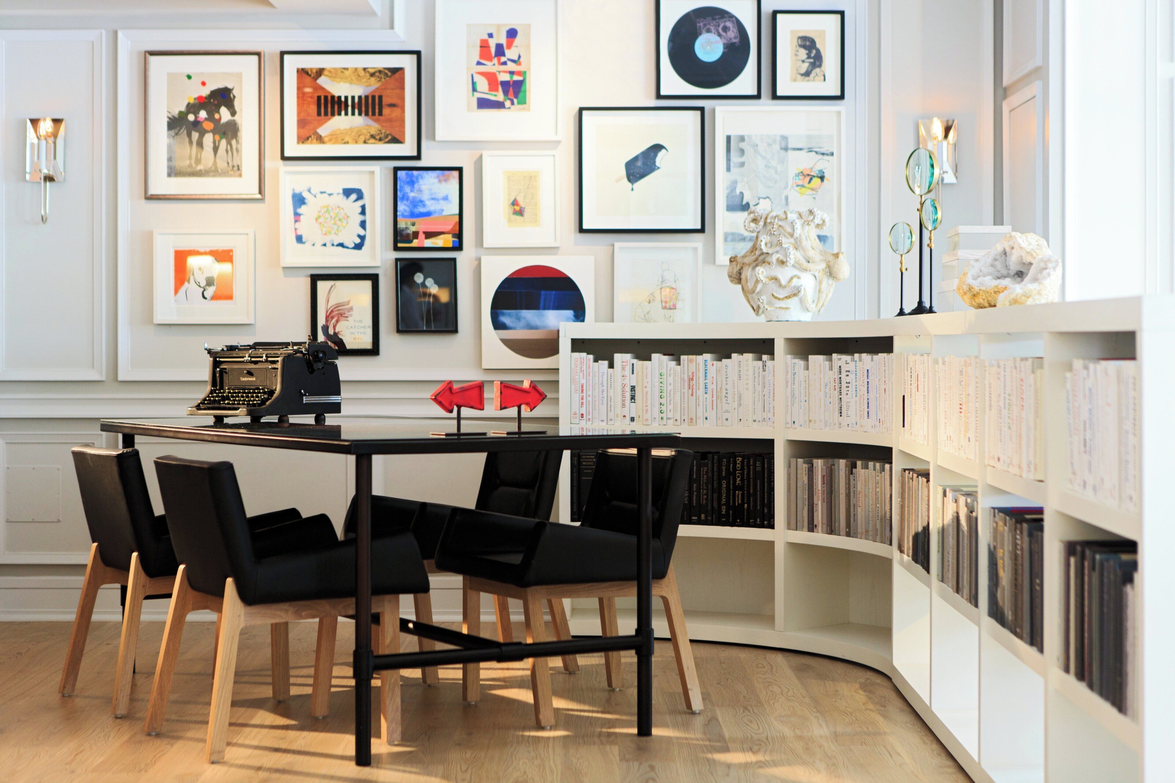 Une bibliothèque moderne avec des étagères, un bureau et des chaises.