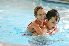 Two children swimming in a pool. - AmericInn by Wyndham Bemidji (Bemidji)