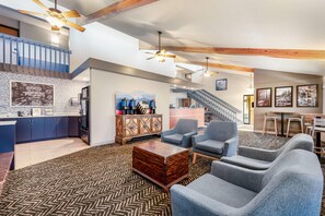 A spacious living area with a kitchen, a dining area, and a staircase leading to an upper level. - AmericInn by Wyndham Bemidji (Bemidji)