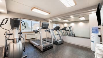 A gym with treadmills, an elliptical, and a water dispenser.