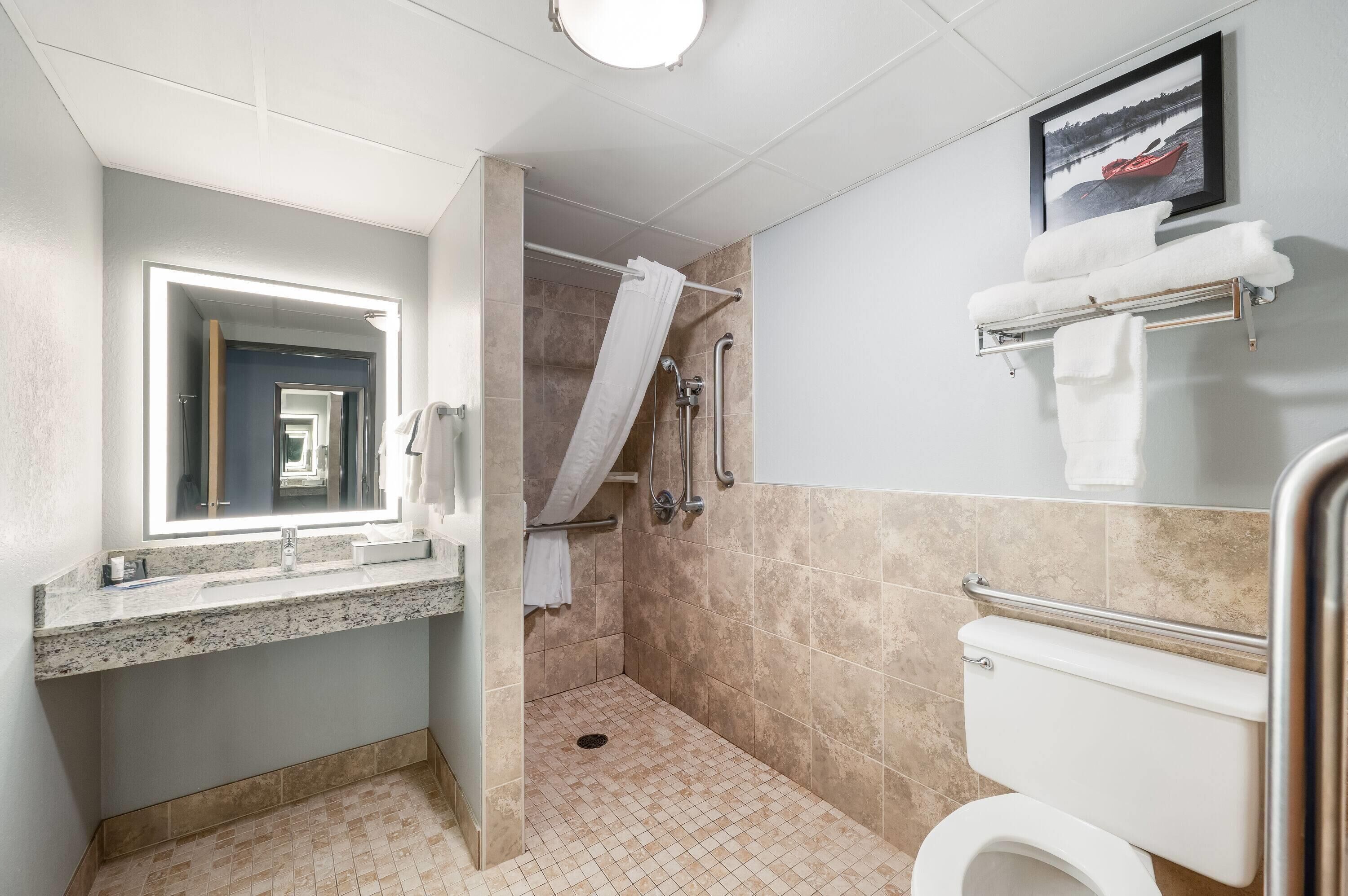 A bathroom with a shower, toilet, and sink.