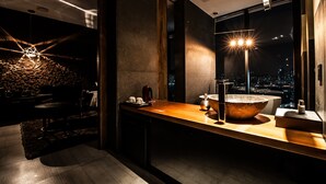 A modern bathroom with a large sink, a mirror, and a view of the city at night. - SR Hotel Sadang (Seoul)
