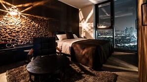 A modern bedroom with a city view, a geometric light fixture, and a wooden accent wall. - SR Hotel Sadang (Seoul)