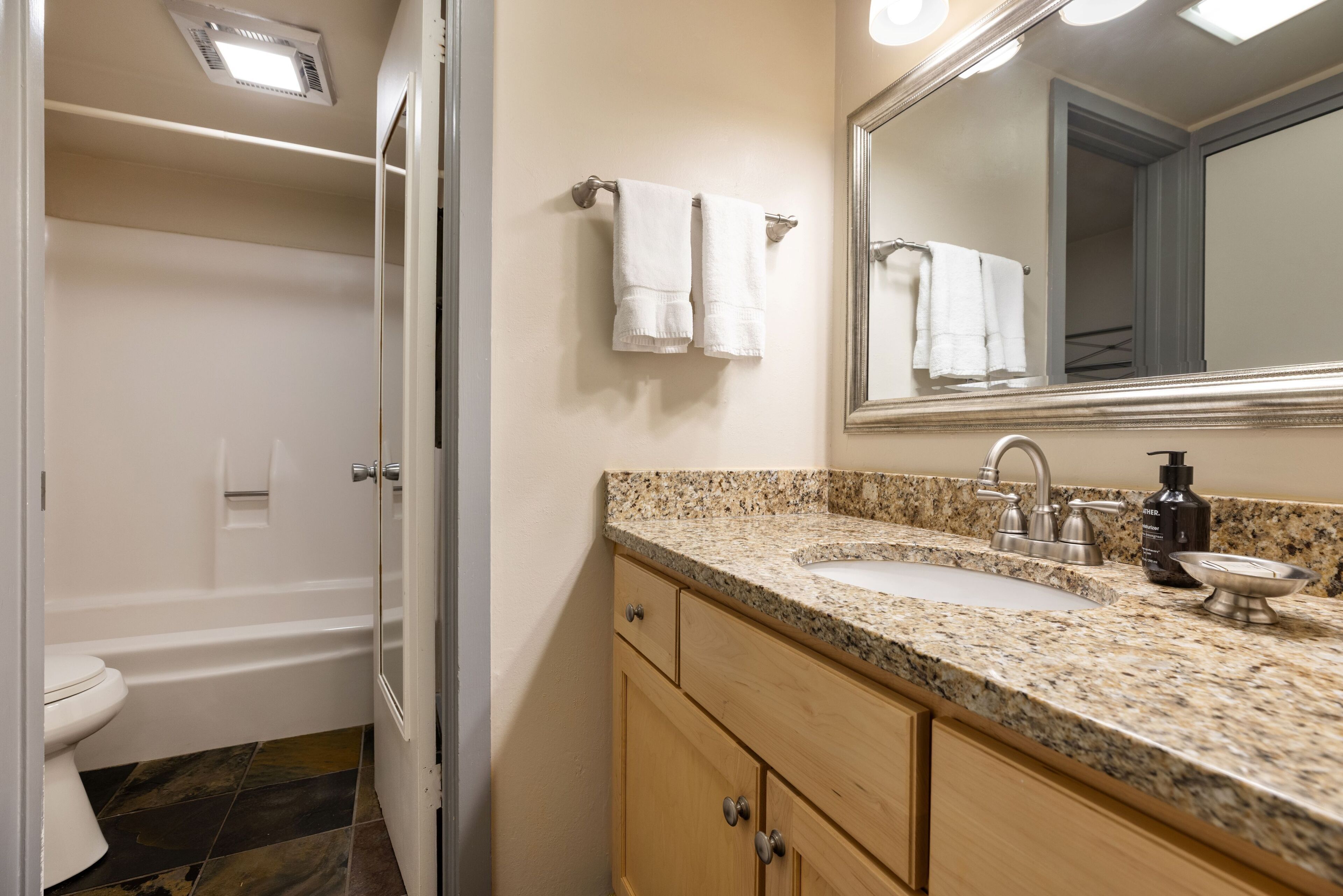 Une salle de bain avec un lavabo, un miroir et un porte-serviettes.