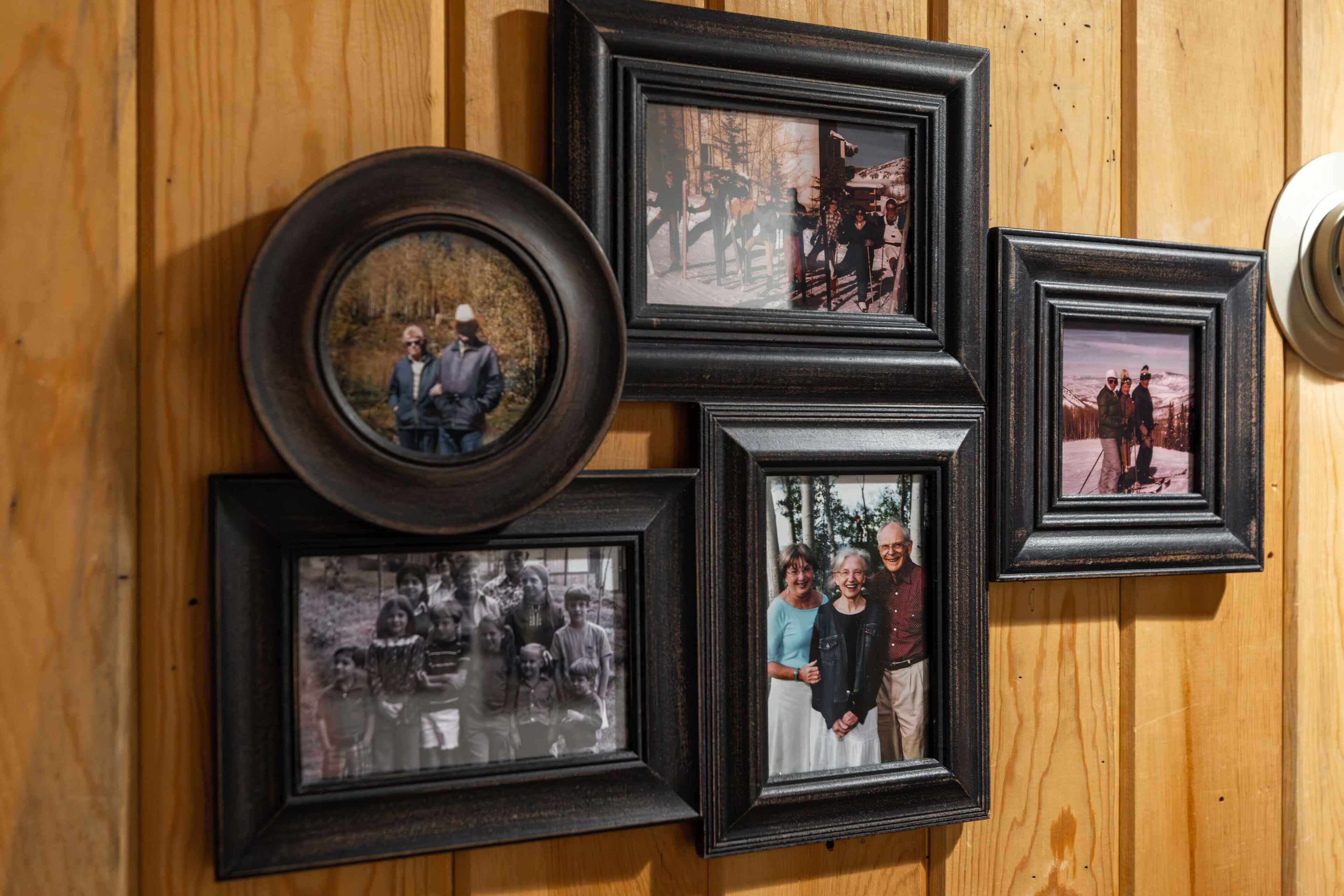 Eine Wand mit mehreren gerahmten Fotos von Personen.