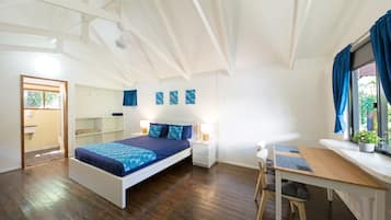 Un dormitorio moderno con una cama grande, un escritorio y una ventana con cortinas.