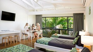 Ein modernes Hotelzimmer mit Balkon, Schreibtisch und zwei Betten.